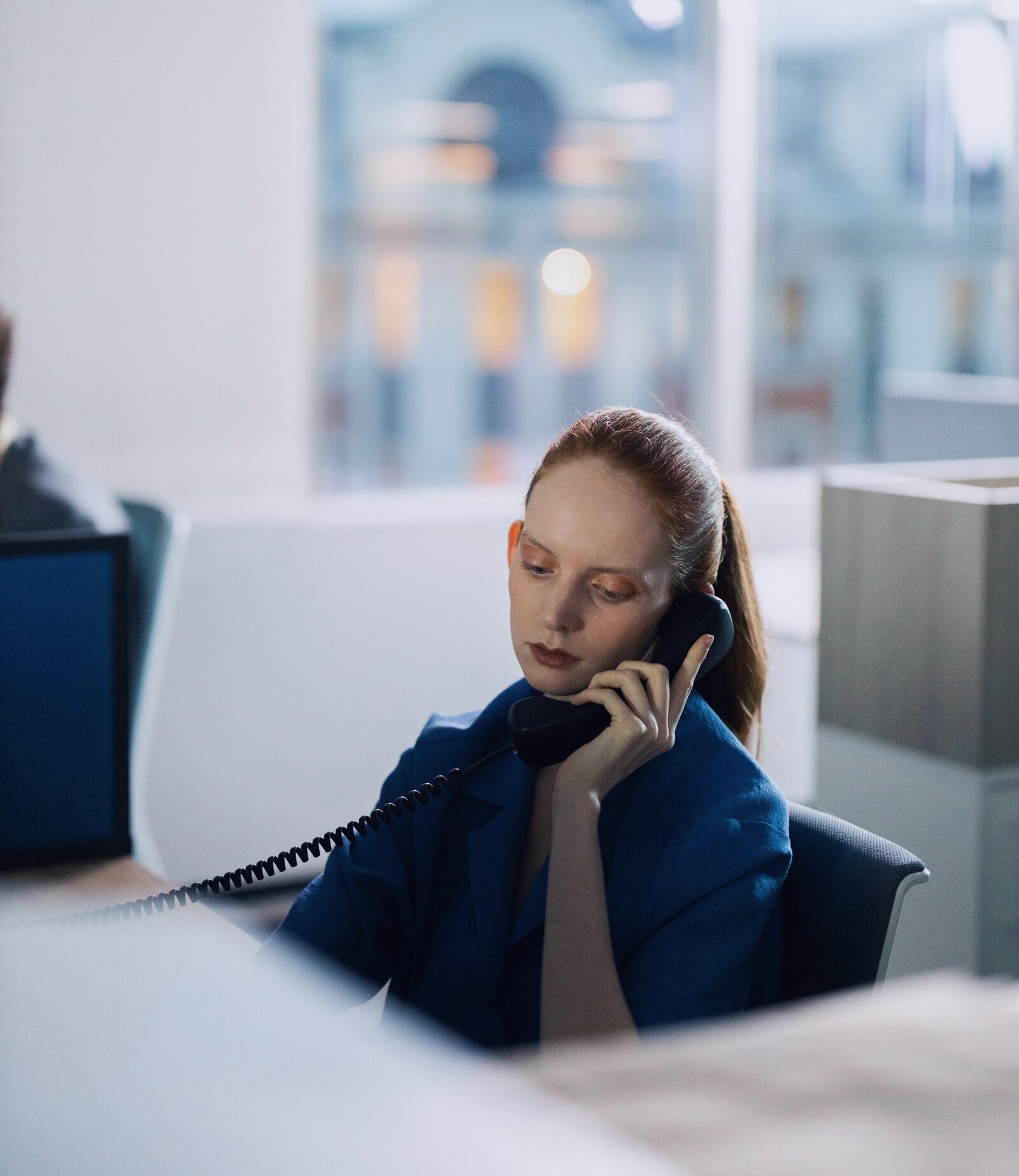 A woman at her desk listening carefully on the phone