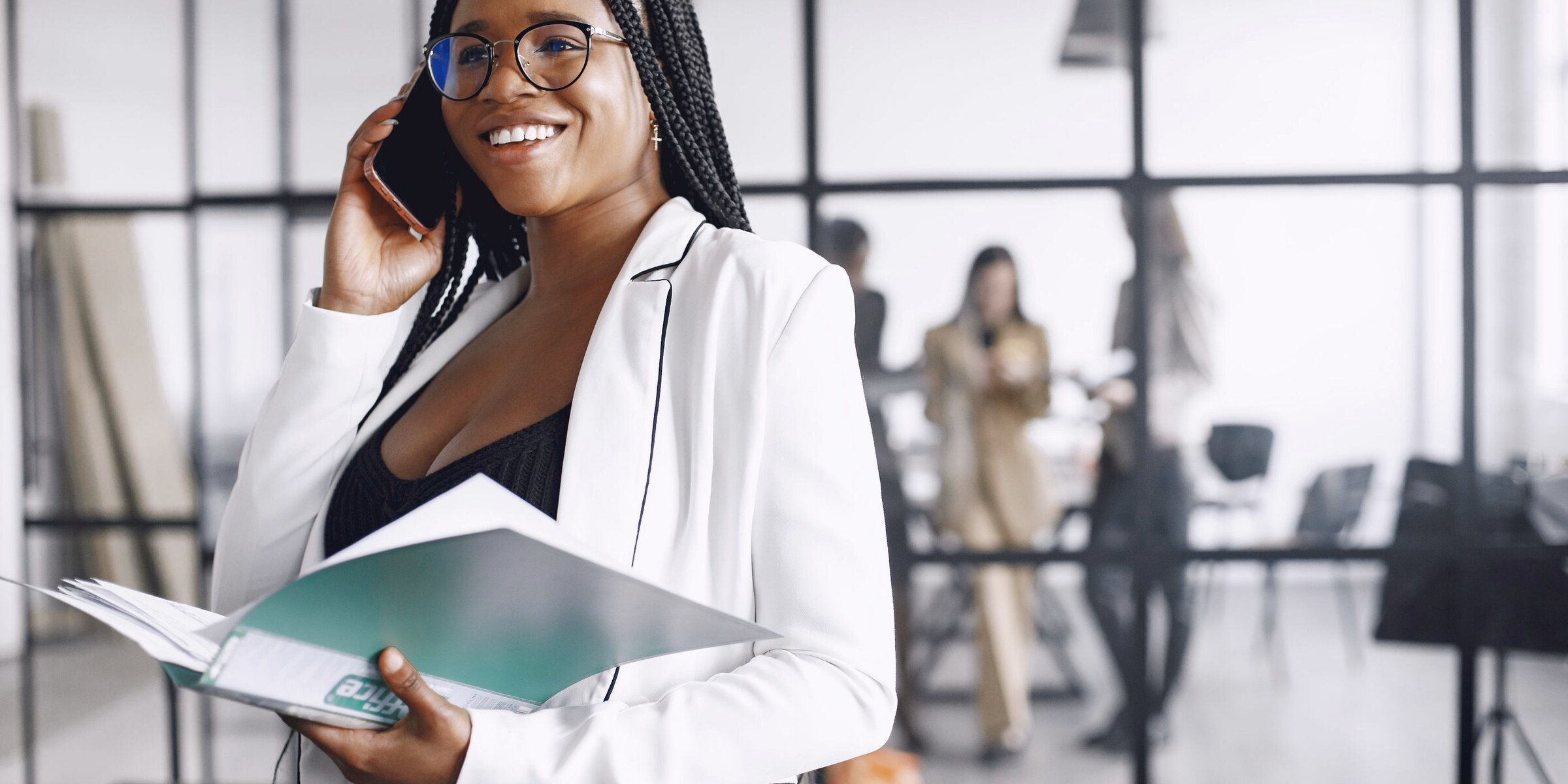 A woman taking a call on her mobile in a bright open-plan office