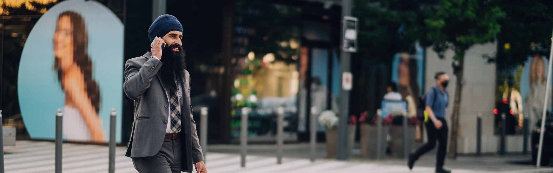 A businessman on a mobile call walking along a city street